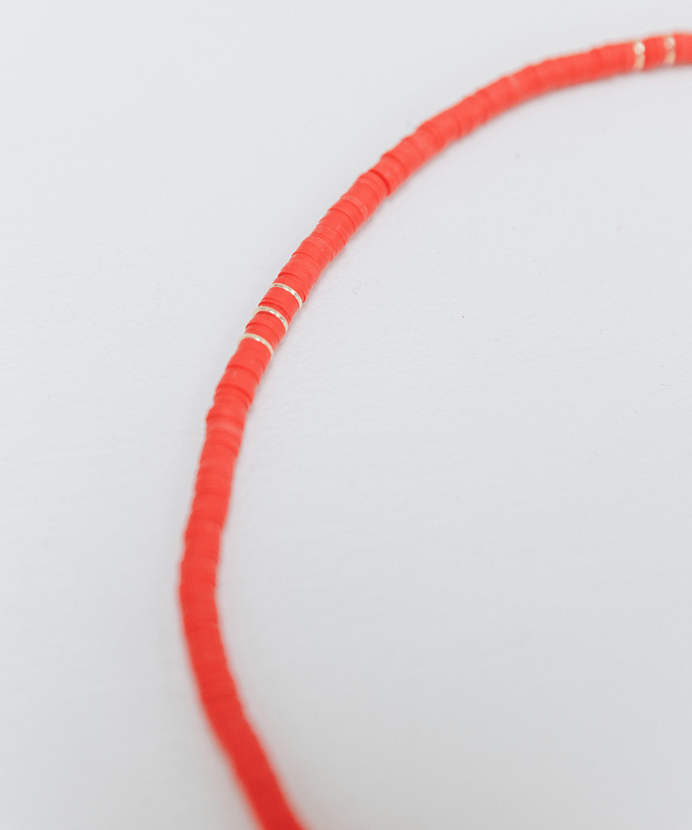 A red beaded band on a white background #color_red