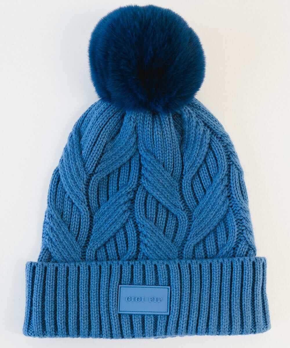 An arctic blue colored knit beanie with a pom-pom on a plain background #color_arctic blue