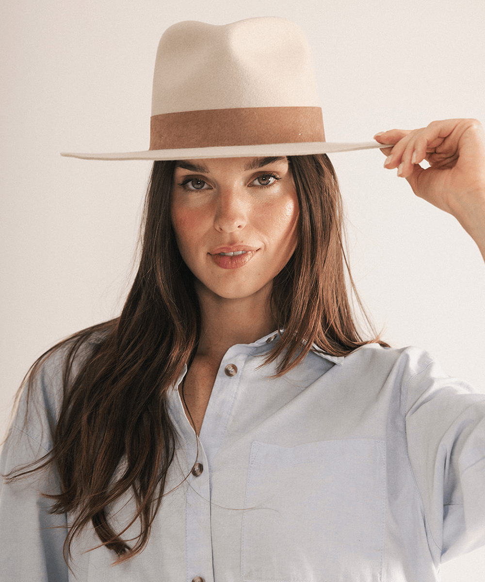 Woman wearing a fedora hat with a brown band on a white background #color_ivory