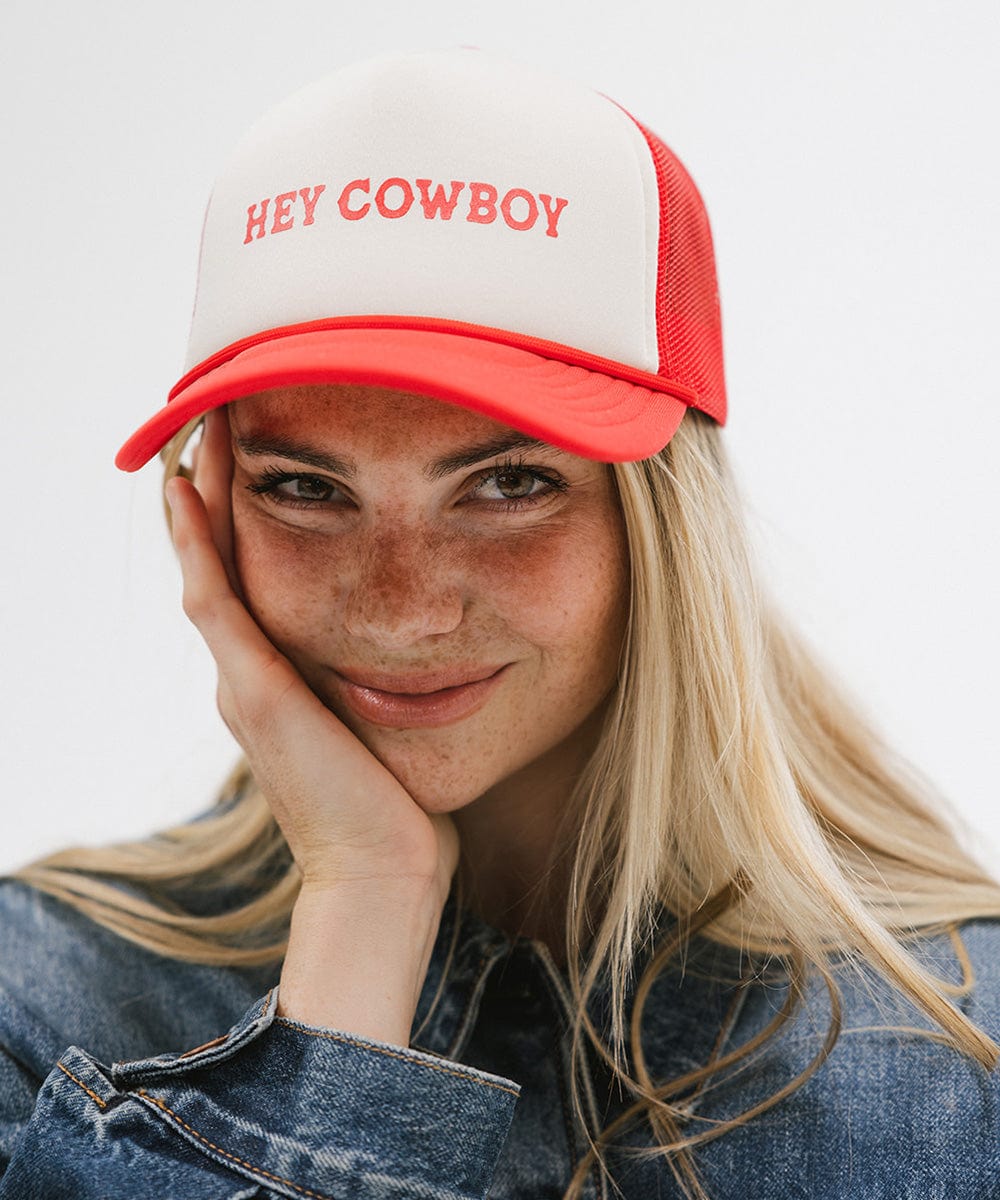 Woman wearing a cream and vintage red cap with 'Hey Cowboy' text and a denim shirt against a plain background #color_cream - vintage red