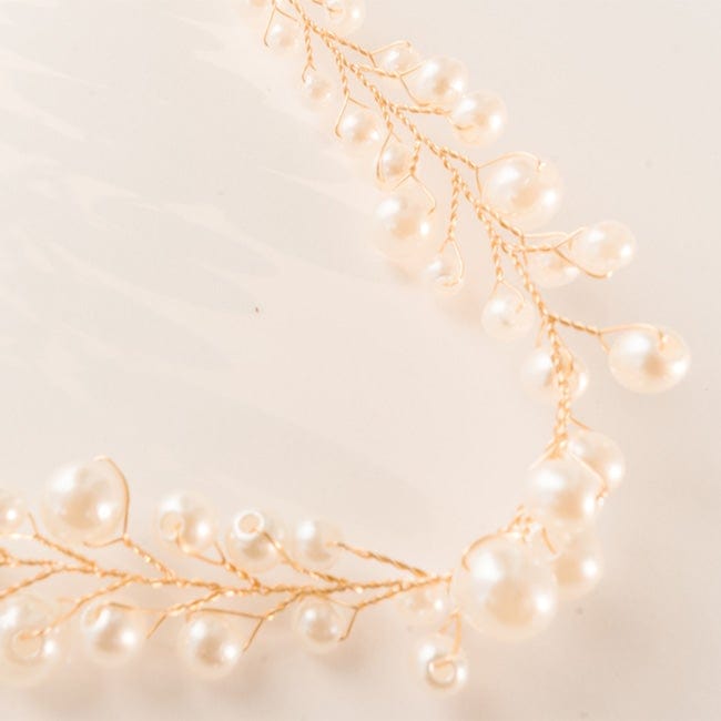 Close up image of a gold decorative hat band with beads on a plain background #color_gold