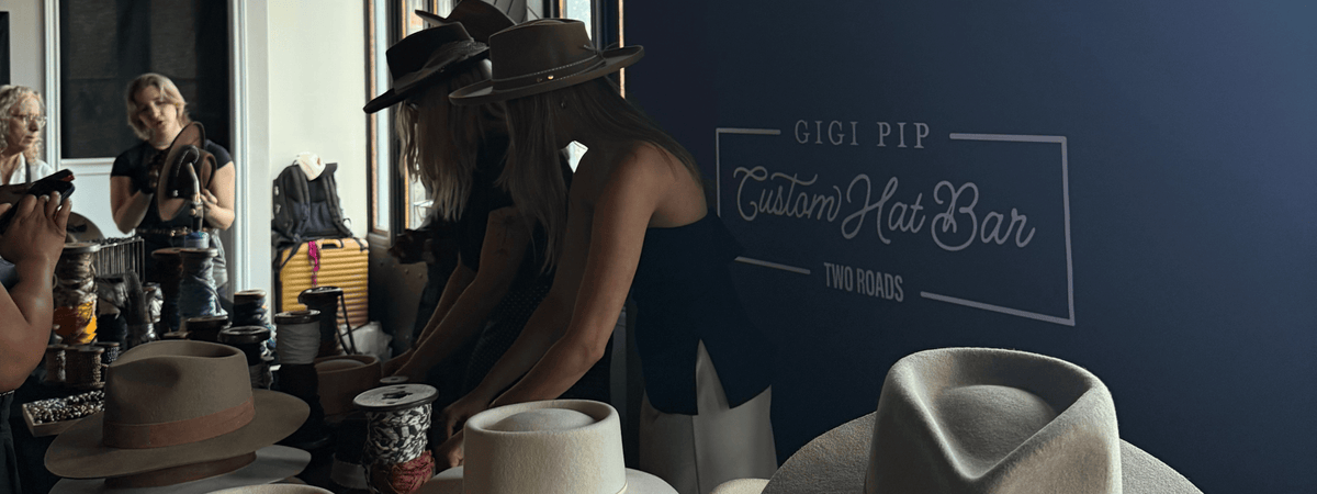 Person selecting hats at a Custom Hat Bar with 'Gigi Pip' branding at a custom hat bar event.
