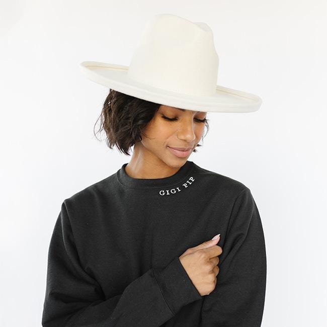 Woman wearing a white hat and a black sweatshirt with the text 'GIGI PIP' against a plain background #color_black