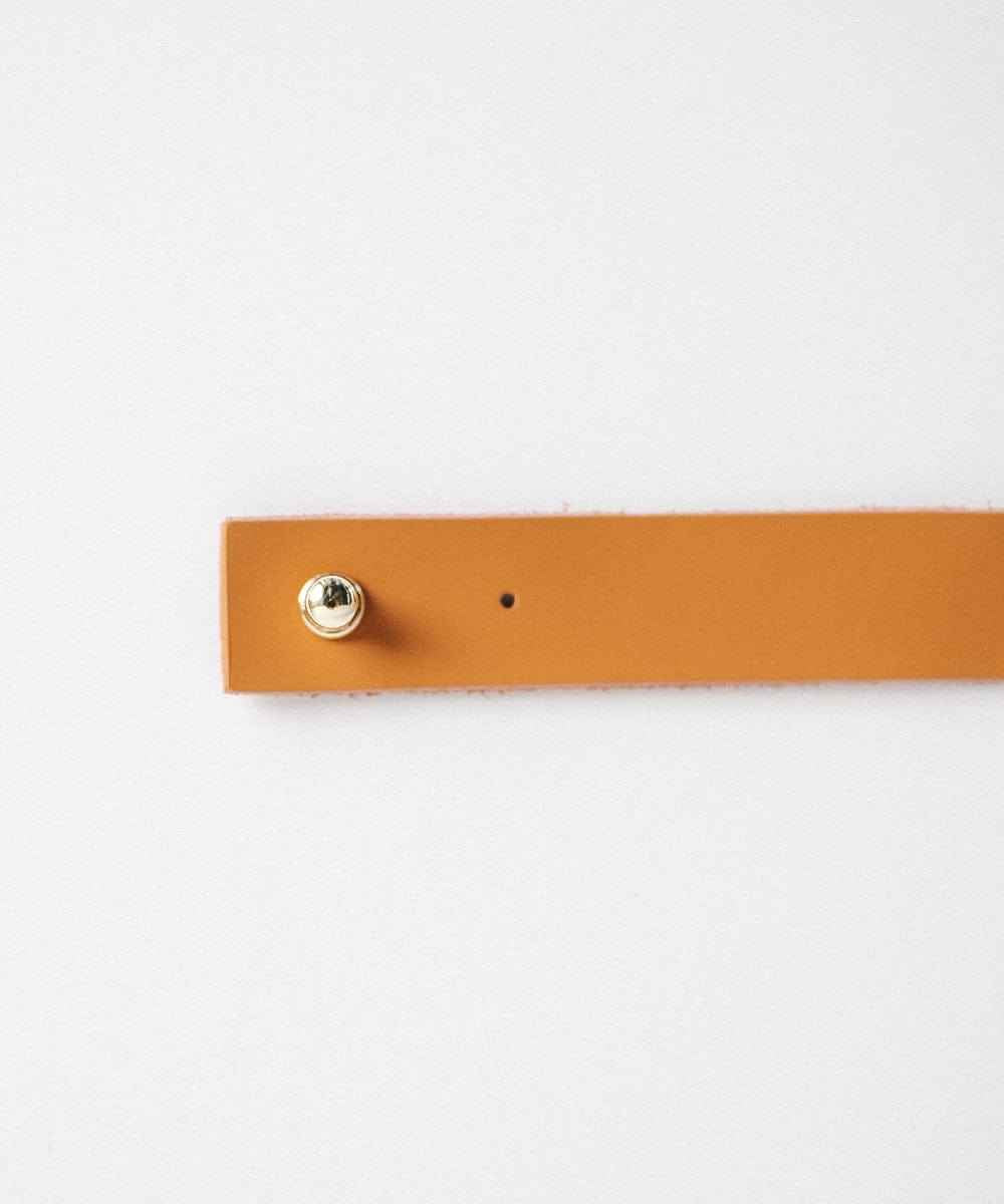 A cognac leather band with pin on a plain background #color_cognac