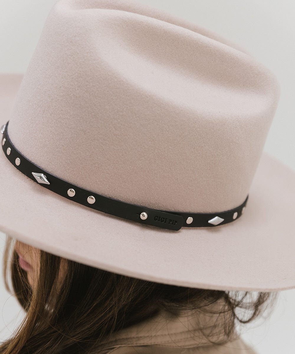 Close up image of a white hat with a black studded leather hat band against a plain background #color_black