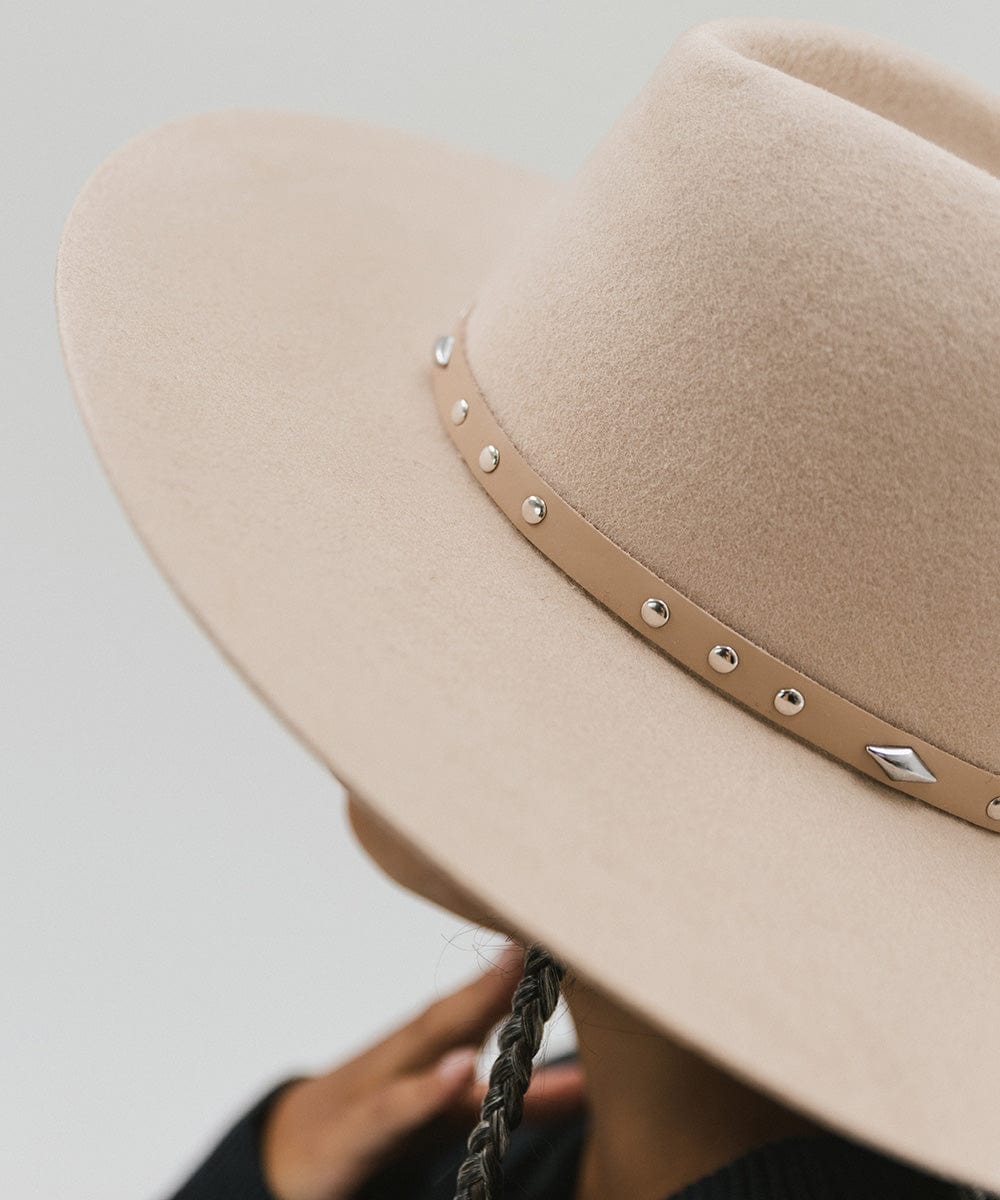 Close up image of a cream hat with a tan studded leather hat band against a plain background #color_tan