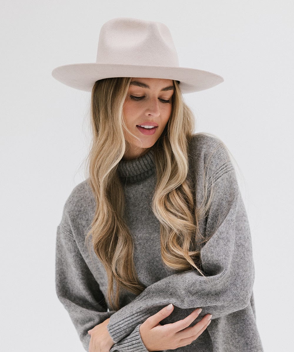 Woman with long hair wearing an ivory colored Rowan Wide Brim Fedora Hat and a grey sweatshirt against a plain background #color_ivory