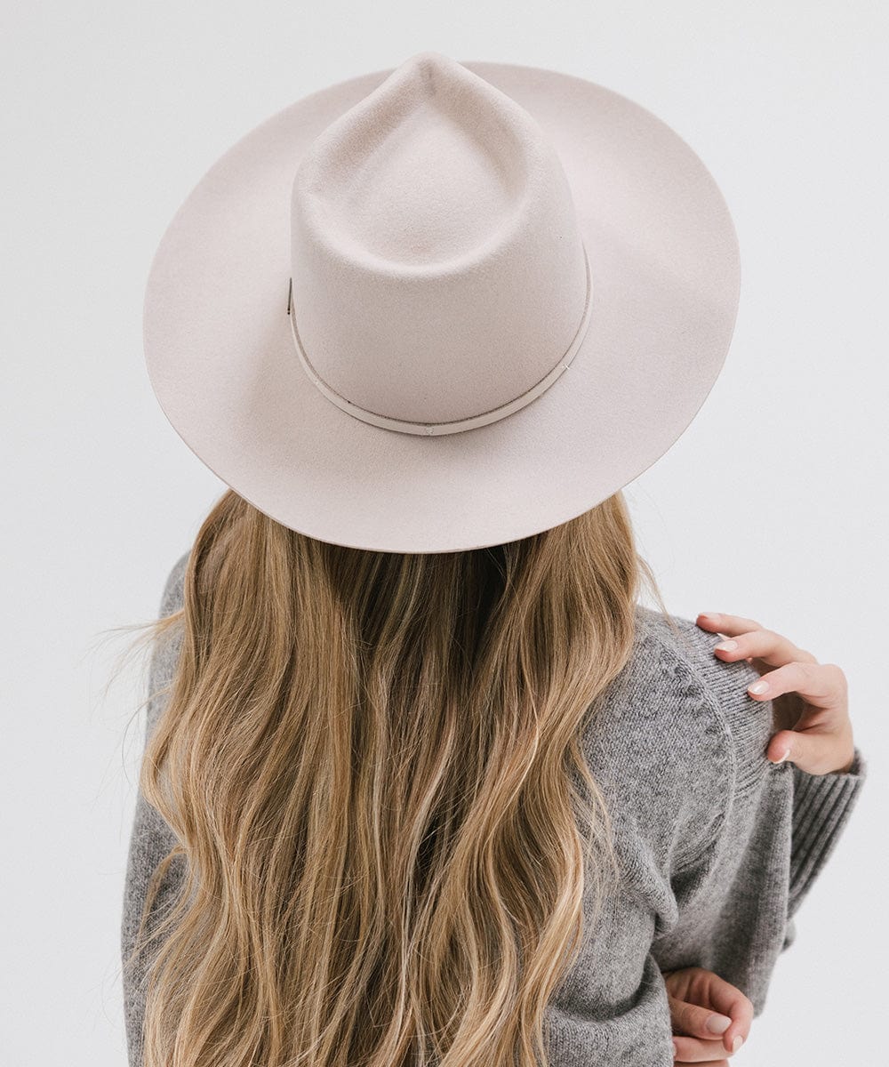 Person wearing an ivory colored Rowan Wide Brim Fedora Hat with a hat band and a grey sweatshirt against a plain background #color_ivory