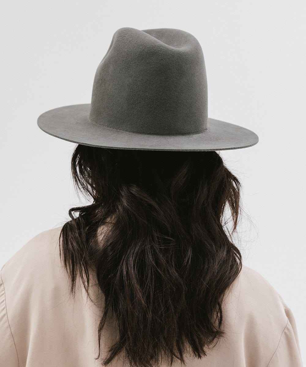 Person wearing a grey tall fedora hat with a plain background #color_dark grey