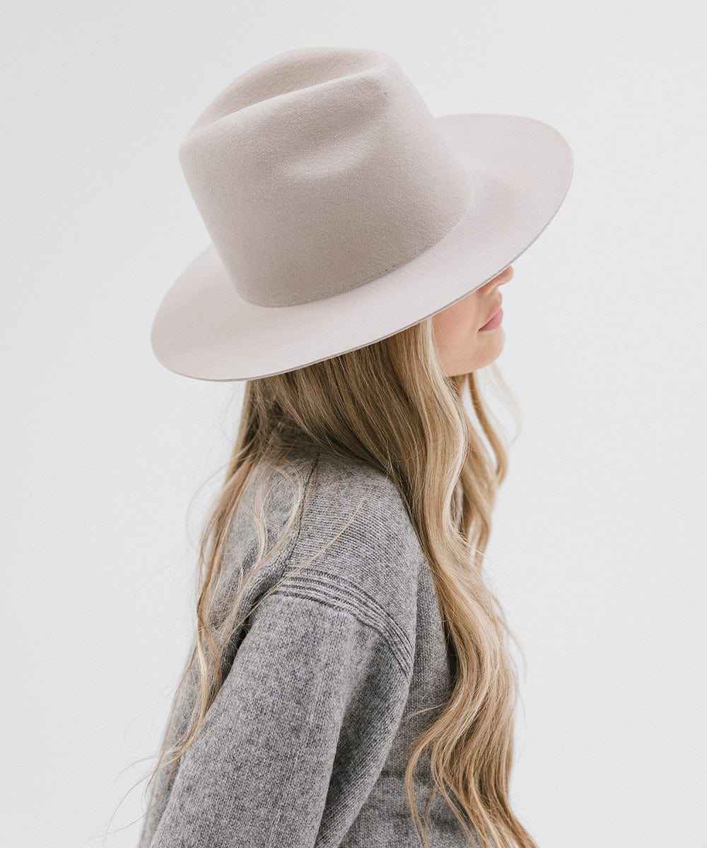 Person wearing an ivory colored hat and grey sweater, facing sideways against a white background #color_ivory