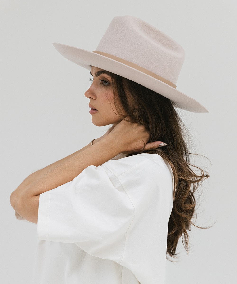 Woman wearing an ivory colored Western hat with a classic cattleman crown, and a white t-shirt, facing sideways against a plain background #color_ivory