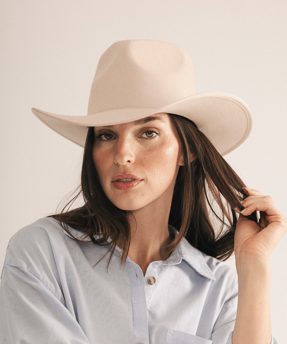 Woman wearing a beige felt hat on a white background #color_cream