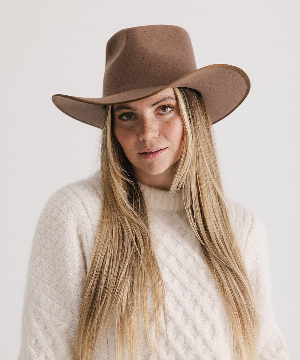 Woman with long hair wearing a chocolate colored felt western hat and a cream sweatshirt against a white background #color_chocolate