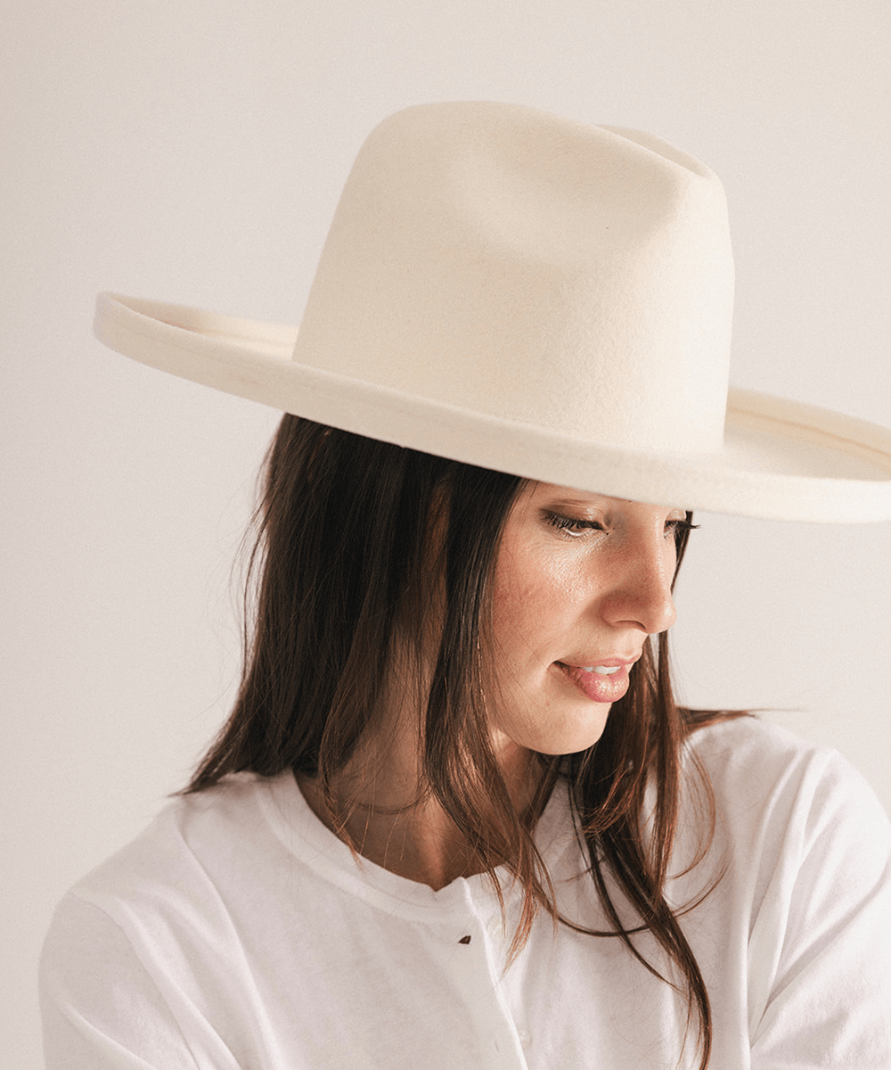 Woman wearing a white pencil brim felt fedora hat on a white background #color_off white