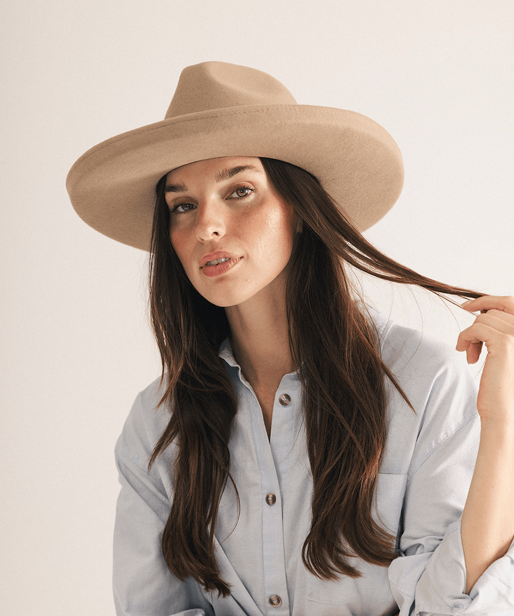 Woman wearing a tan pencil brim felt fedora hat on a white background #color_tan