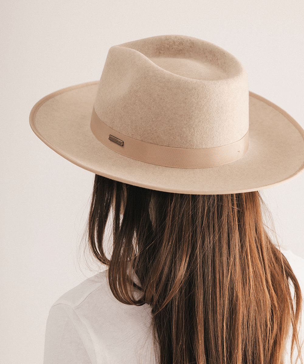 Woman wearing a fedora hat with a band on a white background #color_oatmeal