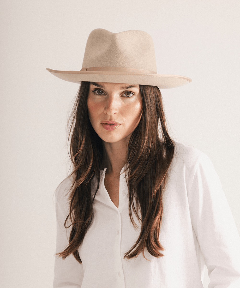 Woman wearing a fedora hat with a band on a white background #color_oatmeal