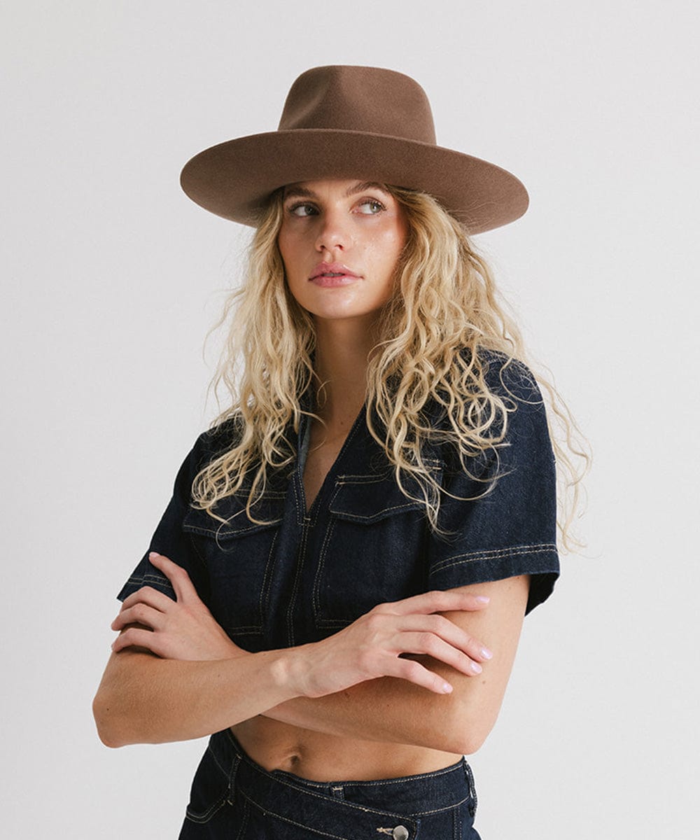 Woman wearing a chocolate colored Rowan Wide Brim Fedora Hat and a denim shirt against a plain background #color_chocolate