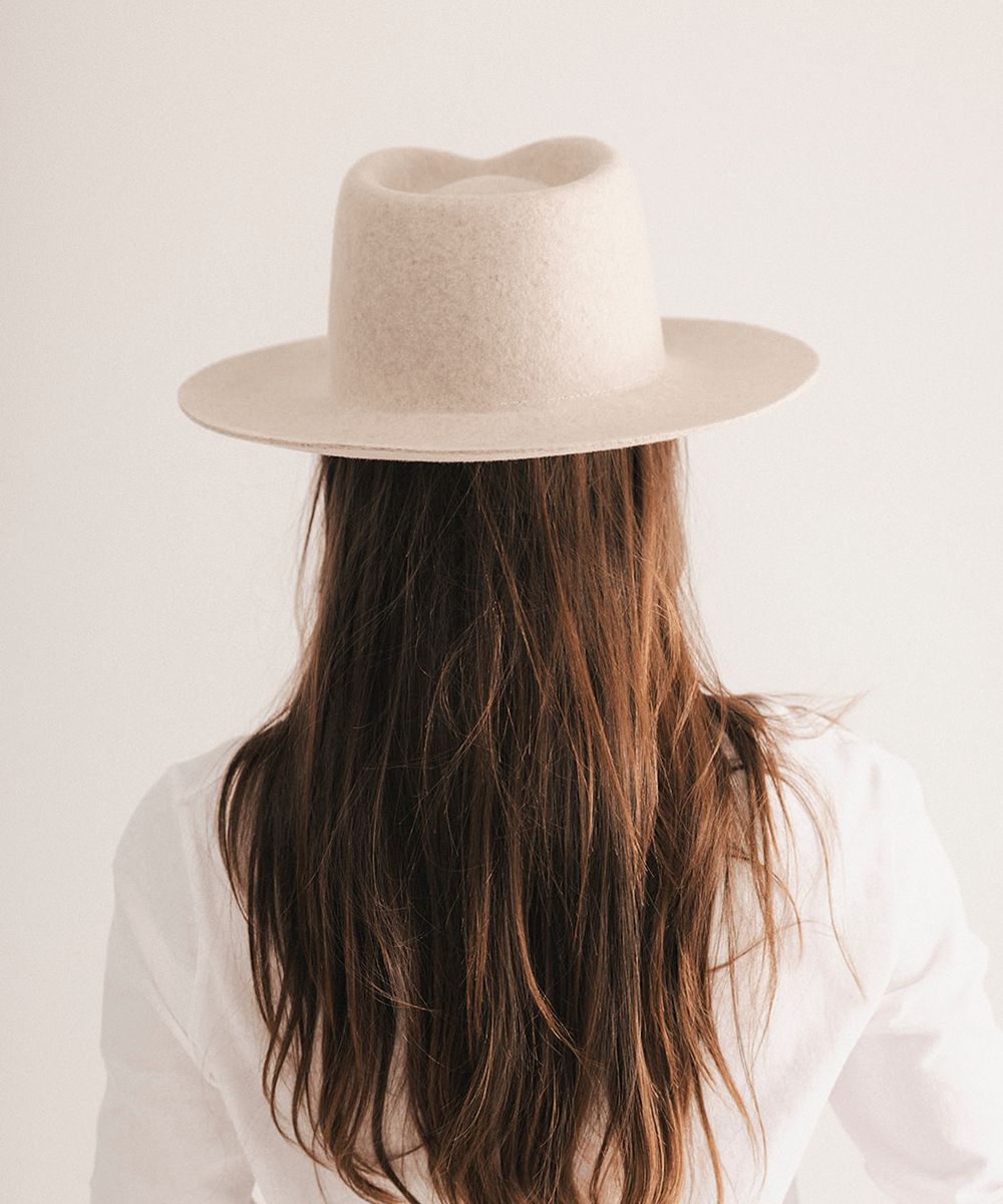 Woman wearing a beige fedora hat with a neutral background #color_mix ivory