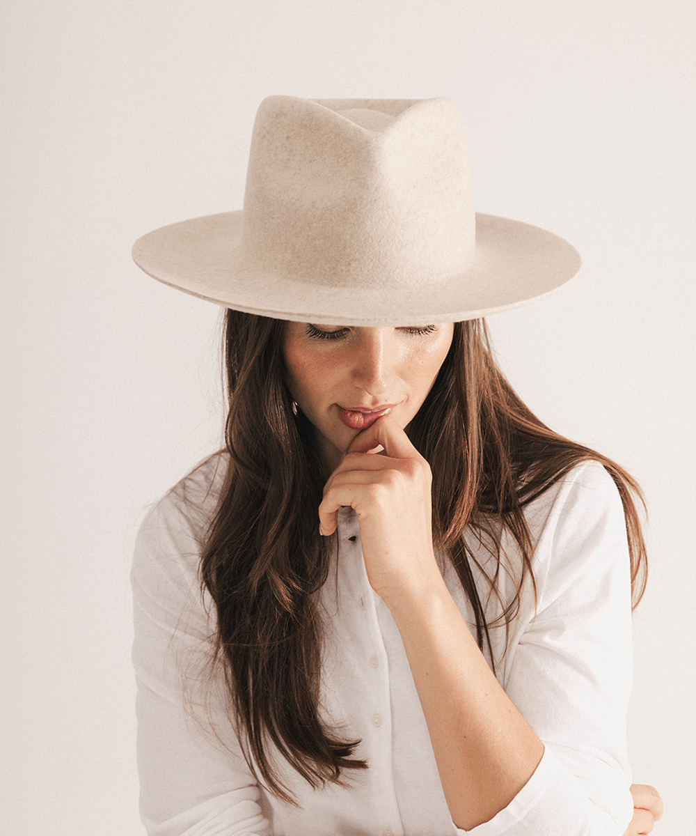 Woman wearing a beige fedora hat with a neutral background #color_mix ivory