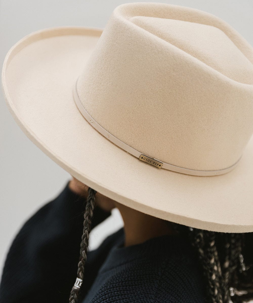 A close up image of a cream Lennon Pencil Brim Fedora Hat with a hat band against a plain background #color_cream