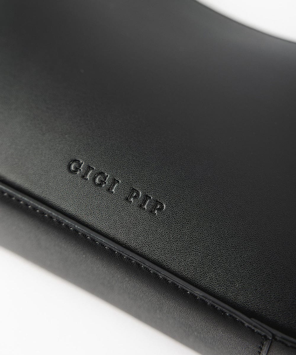 A black genuine leather handbag with the brand label on a plain background  #color_black