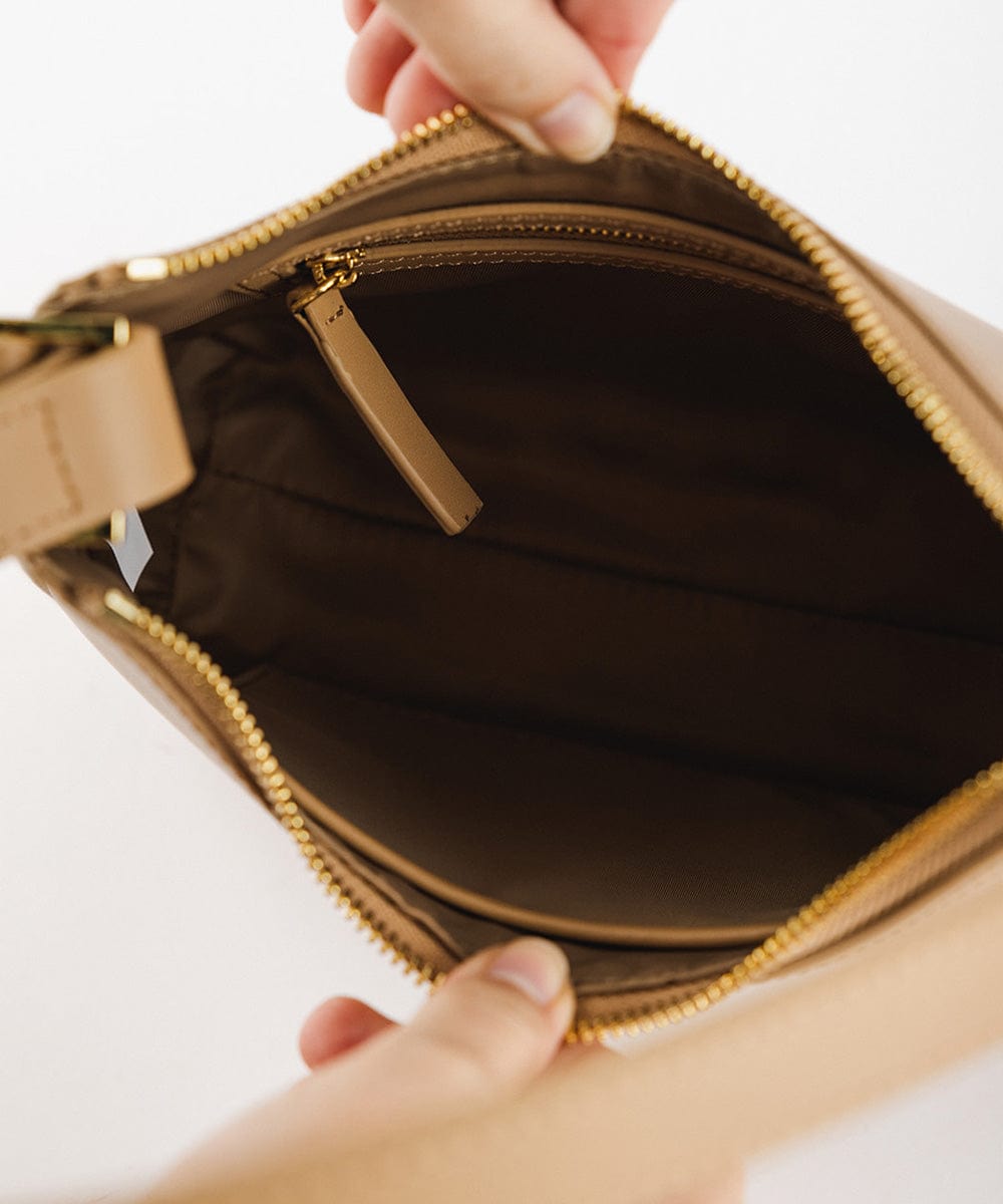 The inside of a tan genuine leather handbag on a plain background  #color_tan