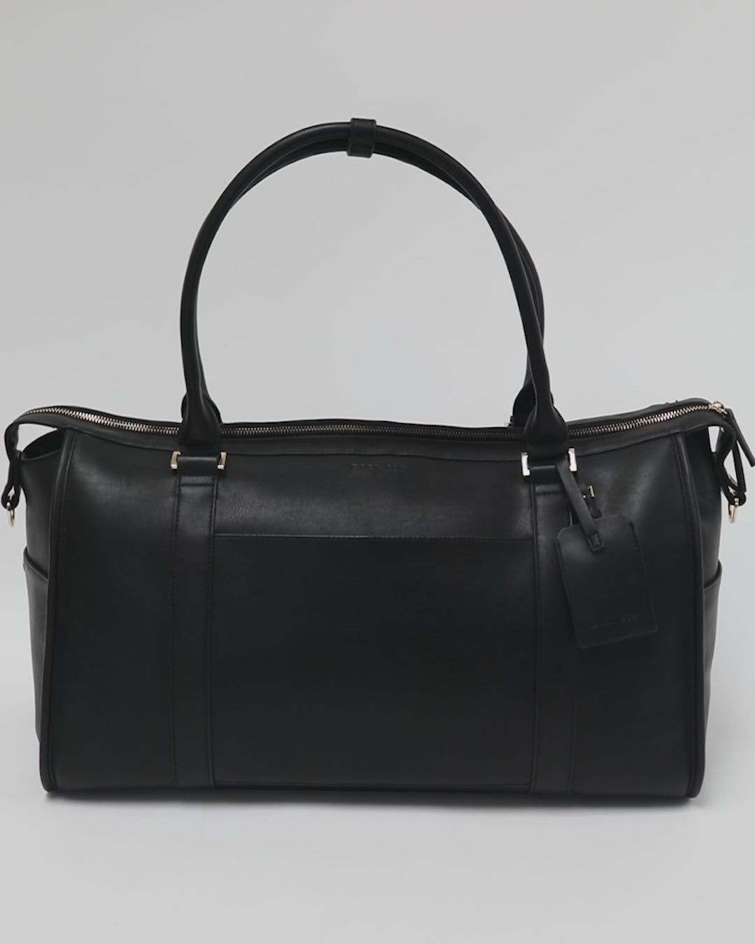 Person showing all the features of a black vegan leather weekender bag against a plain background #color_black