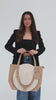 Woman a beige Hayes Hat Carrying Tote bag with a white cowboy hat against a plain background #color_tan