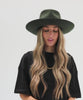 Woman wearing a dark green fedora hat and a black t-shirt against a plain background #color_dark green