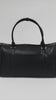 Person showing all the features of a black vegan leather weekender bag against a plain background #color_black