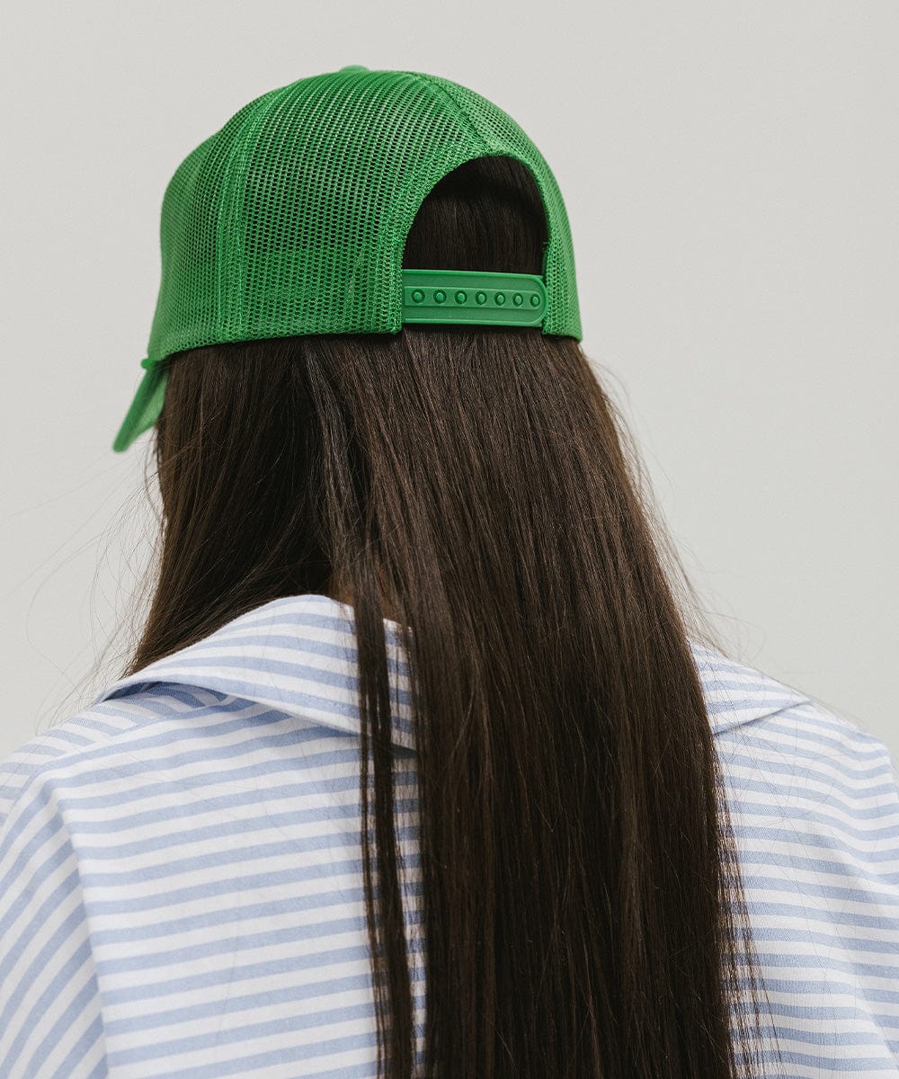 Woman wearing a green cap and a shirt against a plain background  #color_cream - vintage green