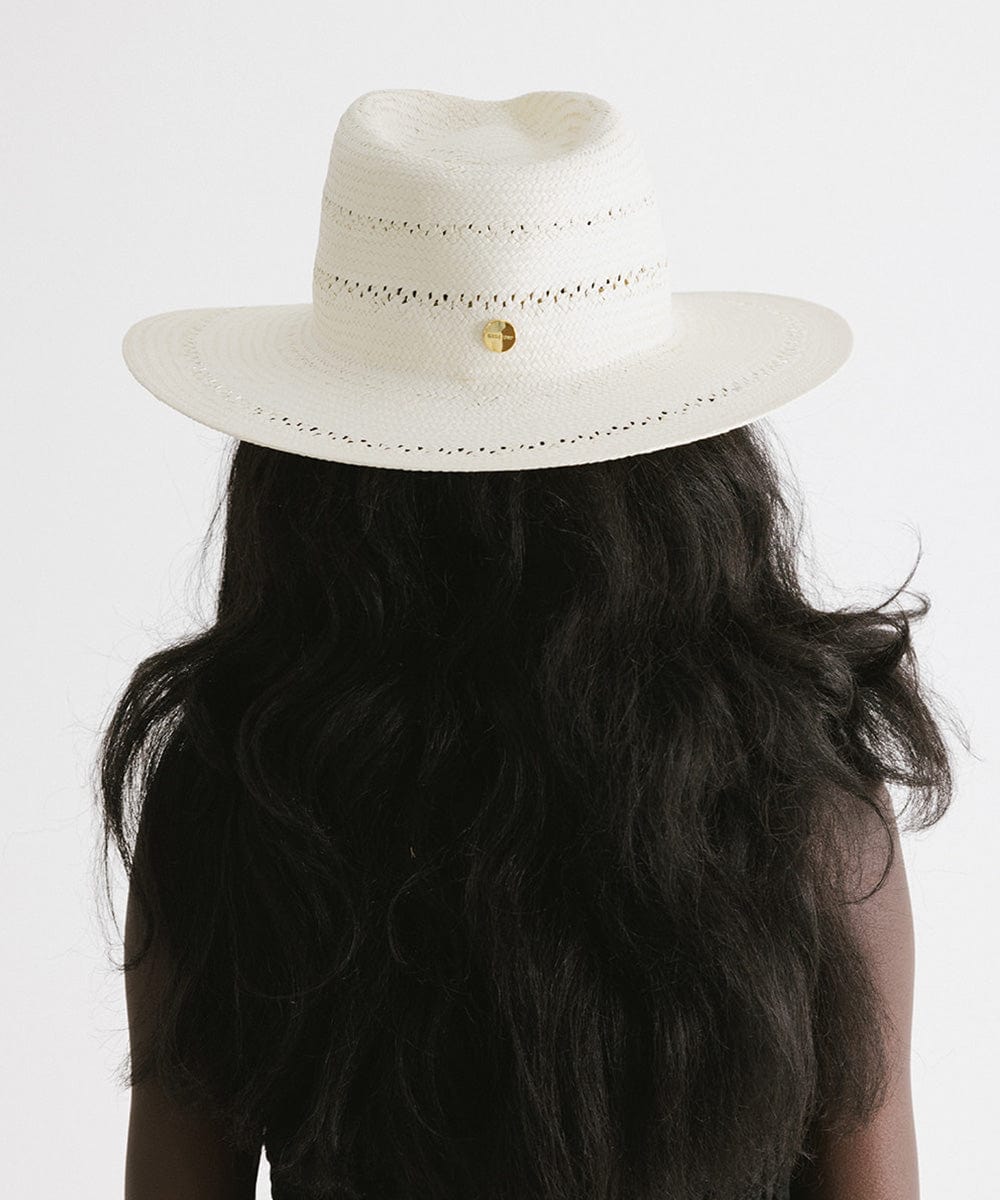 Woman wearing a white straw fedora hat with decorative trim facing behind against a plain background  #color_white