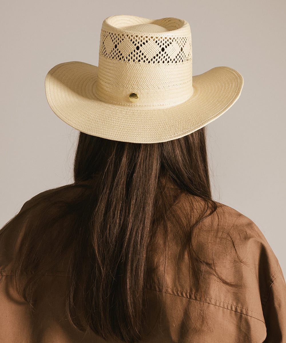 Woman wearing a natural colored straw hat and a brown shirt, facing behind against a plain background #color_natural 
