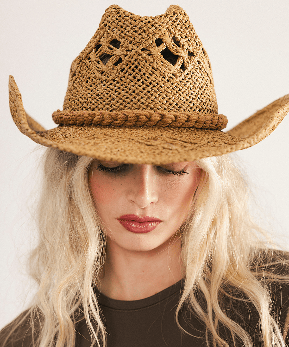 Woman wearing a honey colored paper rope straw cowboy hat with a classic cattleman crown and a wide brim featuring large venting details for airflow against a plain background #color_honey