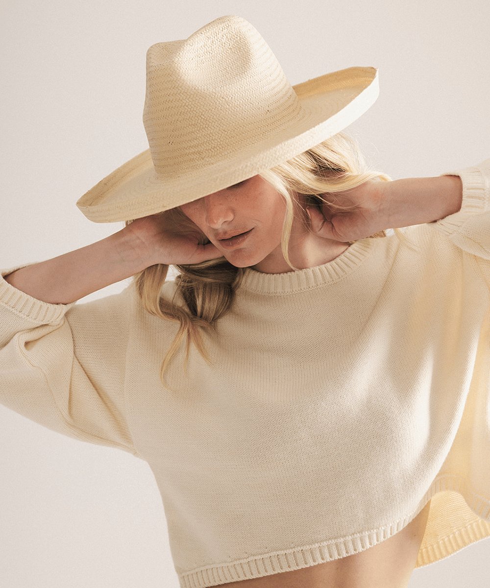Woman wearing a natural colored pencil brim fedora hat made of paper straw, displayed against a white background. #color_natural