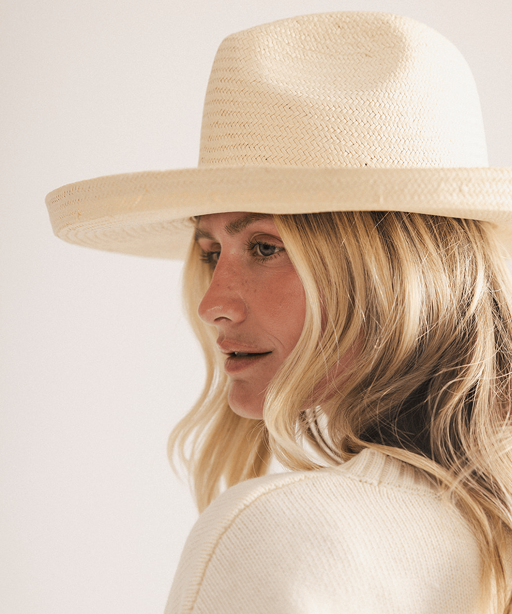 Woman wearing a natural colored pencil brim fedora hat made of paper straw, displayed against a white background. #color_natural
