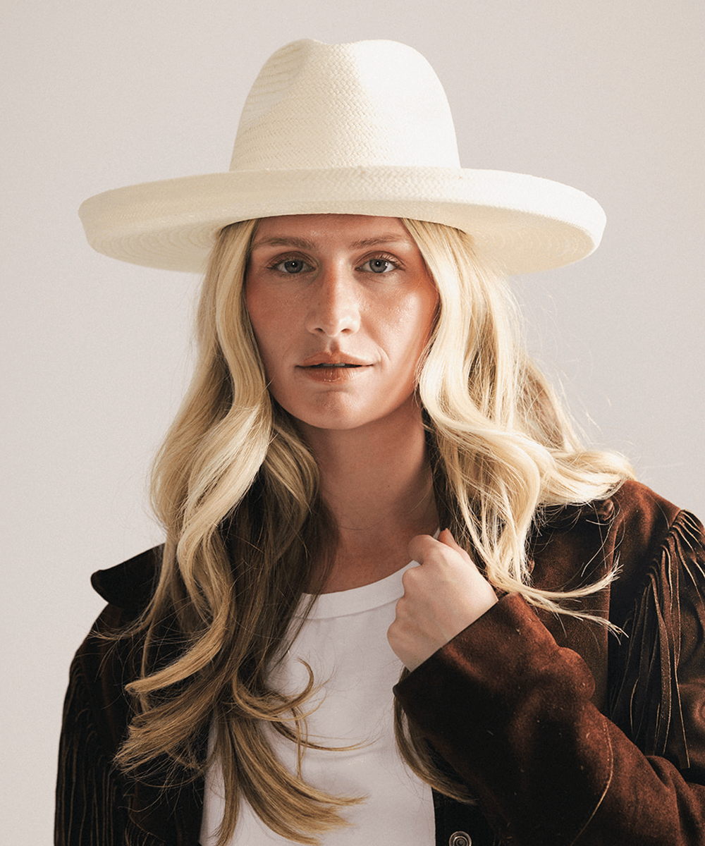 Woman wearing a white pencil brim fedora hat made of paper straw, displayed against a white background. #color_white