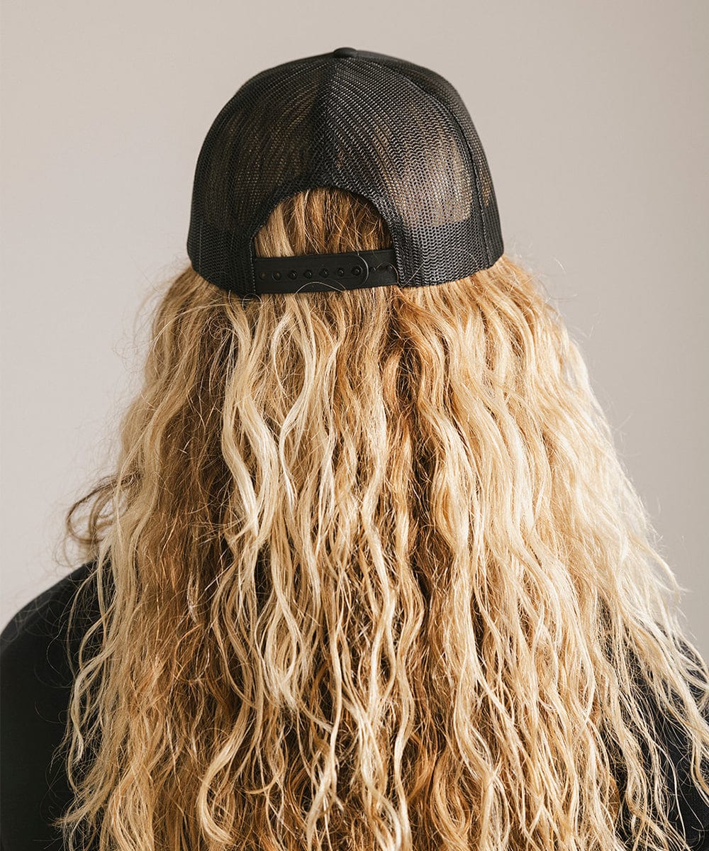 Woman with long hair wearing a black cap against a plain background #color_black 