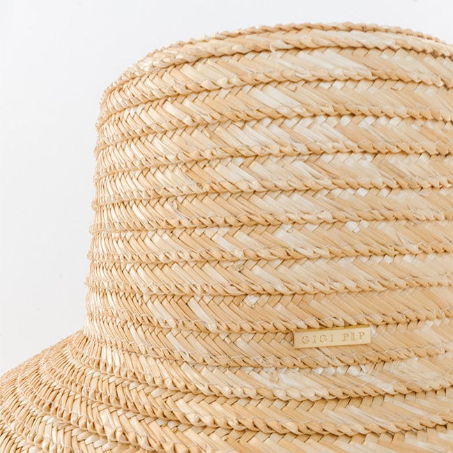 Close up image of a natural colored straw boater hat against a plain background  #color_natural 